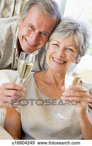 Stock Photo - Couple in living room drinking champagne and smiling. Fotosearch