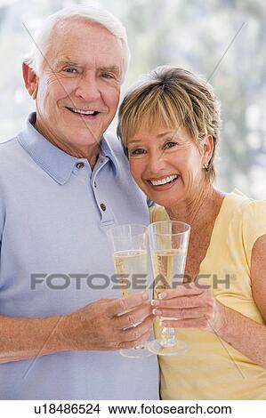 Couple toasting champagne and smiling View Large Photo Image Picture - Couple toasting champagne and smiling. Fotosearch