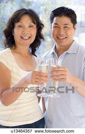 Stock Photo - Couple toasting champagne and smiling. Fotosearch
