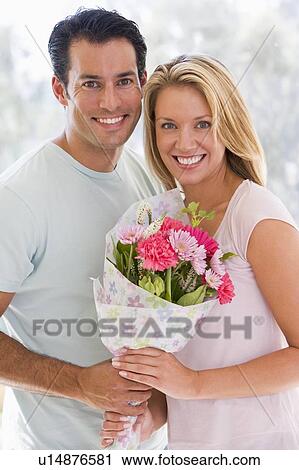 Husband and wife holding flowers and smiling View Large Photo Image Stock Image - Husband and wife holding flowers and smiling. Fotosearch