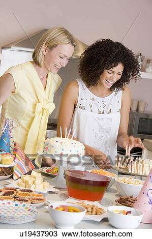Two women at party getting sandwiches smiling View Large Photo Image Stock Image - Two women at party getting sandwiches smiling. Fotosearch