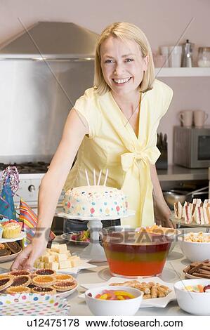 Woman at party getting tart from food table smiling View Large Photo Image Stock Photo - Woman at party getting tart from food table smiling. Fotosearch