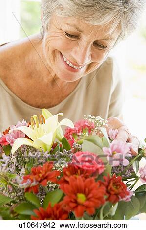 Woman with flowers smiling View Large Photo Image Stock Image - Woman with flowers smiling. Fotosearch