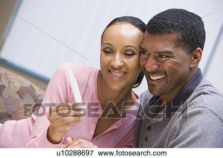 Stock Photo - Couple with pregnancy test smiling. Fotosearch