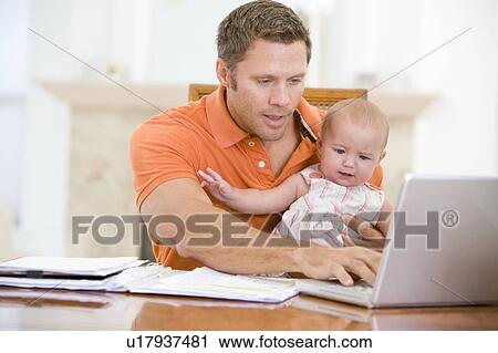 Father and baby in dining room with laptop View Large Photo Image Stock Image - Father and baby in dining room with laptop. Fotosearch