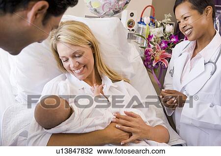 New parents with baby talking to doctor and smiling View Large Photo Image Stock Image - New parents with baby talking to doctor and smiling. Fotosearch