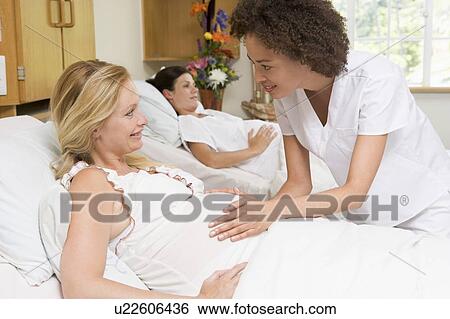 Nurse checking pregnant woman's belly and smiling View Large Photo Image Stock Photograph - Nurse checking pregnant woman's belly and smiling. Fotosearch