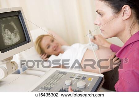 Pregnant woman getting ultrasound from doctor View Large Photo Image Stock Image - Pregnant woman getting ultrasound from doctor. Fotosearch