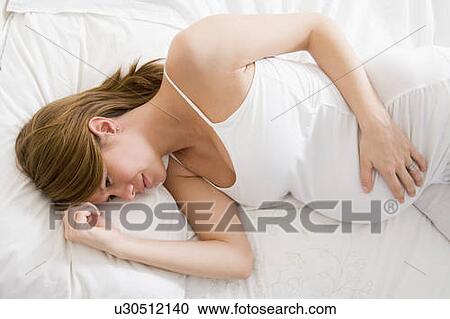 Pregnant woman lying in bed View Large Photo Image Stock Image - Pregnant woman lying in bed. Fotosearch