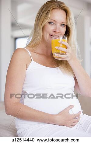 Pregnant woman with glass of orange juice View Large Photo Image Stock Image - Pregnant woman with glass of orange juice. Fotosearch