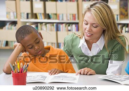 Student in class reading with teacher View Large Photo Image Stock Image - Student in class reading with teacher. Fotosearch