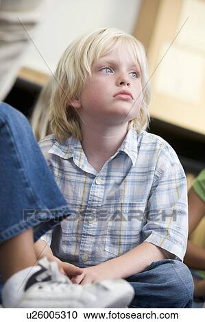 Stock Image - Student in class sitting on floor bored (selective focus). Fotosearch