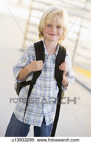 Stock Photography - Student standing outdoors smiling (high key). Fotosearch