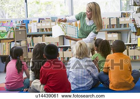 Stock Image - Teacher in class reading to students. Fotosearch