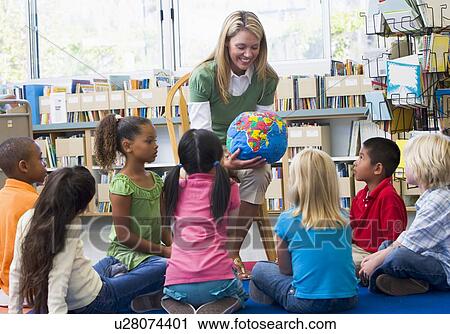 Teacher in class showing students a globe View Large Photo Image Stock Image - Teacher in class showing students a globe. Fotosearch