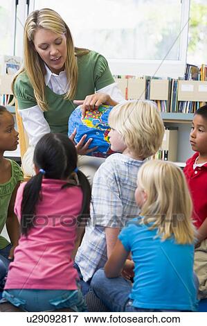 Teacher in class showing students a globe (selective focus) View Large Photo Image Stock Photo - Teacher in class showing students a globe (selective focus). Fotosearch