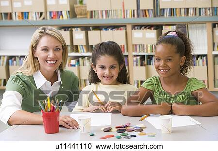 Stock Image - Two students in art class with teacher. Fotosearch