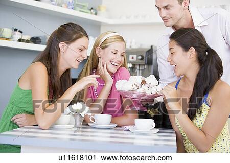 Man offering sweet treats to three young women View Large Photo Image Stock Image - Man offering sweet treats to three young women. Fotosearch