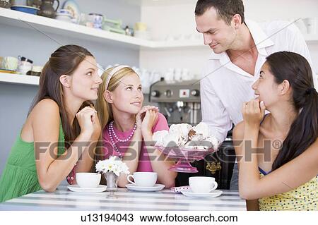 Man offering sweet treats to three young women View Large Photo Image Stock Image - Man offering sweet treats to three young women. Fotosearch