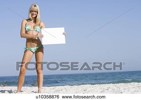 Woman holding a blank card on a beach View Large Photo Image Stock Photograph - Woman holding a blank card on a beach. Fotosearch