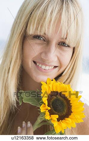 Woman holding a sunflower View Large Photo Image Stock Photo - Woman holding a sunflower. Fotosearch