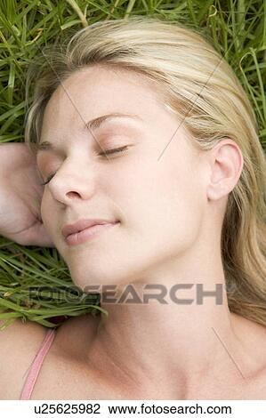 Woman lying on grass View Large Photo Image Stock Image - Woman lying on grass. Fotosearch