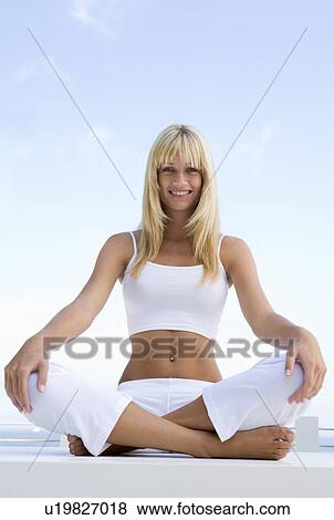 Stock Photo - Woman sitting and meditating outdoors. Fotosearch