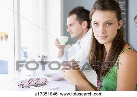 Stock Photograph - Young couple having tea in a cafeteria. Fotosearch