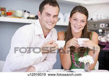 Stock Photo - Young couple sitting at a table and having tea together. Fotosearch