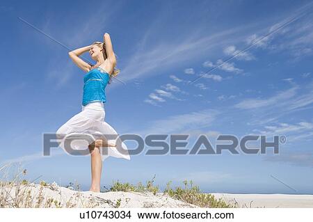 Young woman posing on a sand hill View Large Photo Image Picture - Young woman posing on a sand hill. Fotosearch