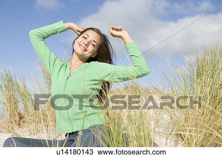 Stock Image - Young woman posing on a sand hill. Fotosearch