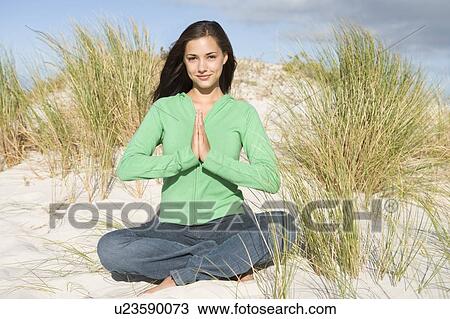 Stock Image - Young woman posing on a sand hill. Fotosearch