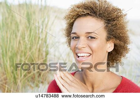 Stock Photo - Young woman posing on a sand hill. Fotosearch