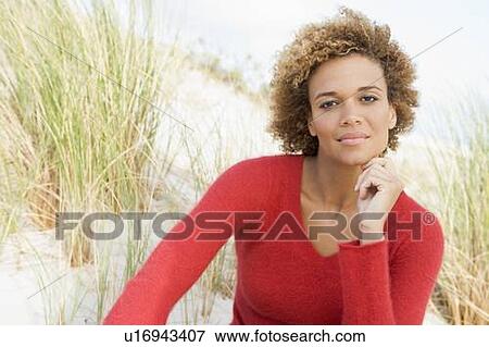 Young woman posing on a sand hill View Large Photo Image Stock Photo - Young woman posing on a sand hill. Fotosearch