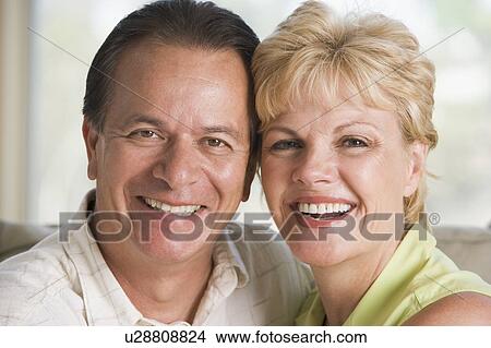 Couple relaxing in living room and smiling View Large Photo Image Picture - Couple relaxing in living room and smiling. Fotosearch