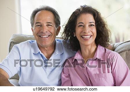 Stock Image - Couple relaxing in living room and laughing. Fotosearch