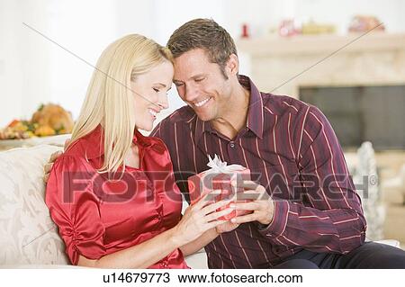 Stock Image - Couple Sharing Christmas Present. Fotosearch