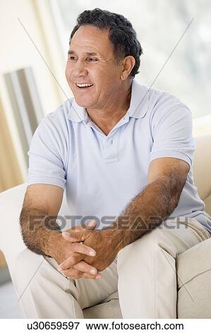 Man in living room smiling View Large Photo Image Stock Photo - Man in living room smiling. Fotosearch