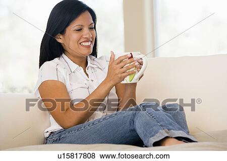 Woman in living room with coffee smiling View Large Photo Image Stock Photo - Woman in living room with coffee smiling. Fotosearch