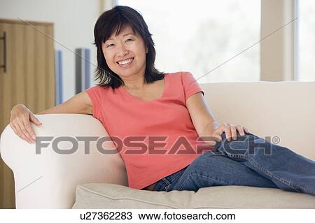 Woman relaxing in living room smiling View Large Photo Image Stock Image - Woman relaxing in living room smiling. Fotosearch