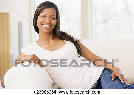 Woman sitting in living room View Large Photo Image Picture - Woman sitting in living room. Fotosearch