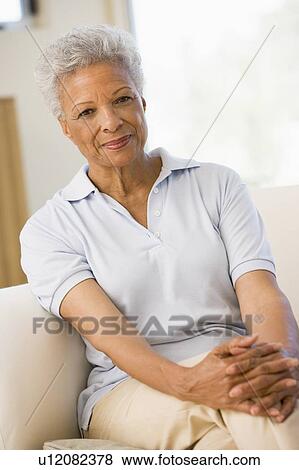 Stock Photo - Woman sitting in living room. Fotosearch