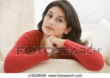 Stock Photo - Woman sitting in living room. Fotosearch