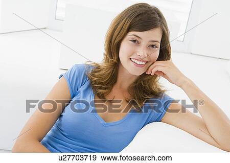 Stock Photo - Woman sitting in living room. Fotosearch