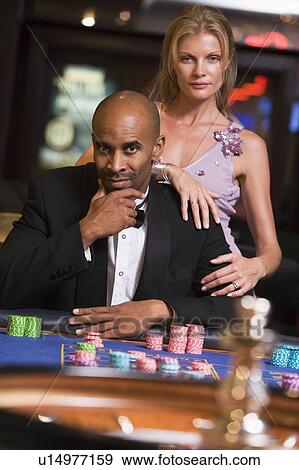 Stock Photo - Couple in casino playing roulette (selective focus). Fotosearch
