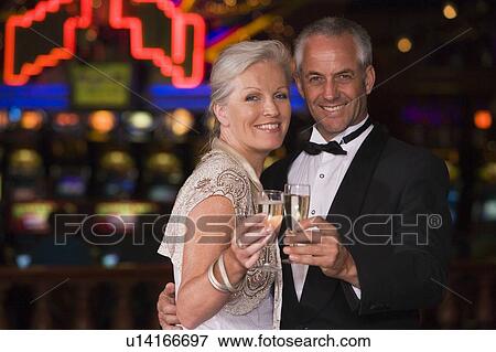 Stock Photo - Couple in casino with champagne smiling (selective focus). Fotosearch