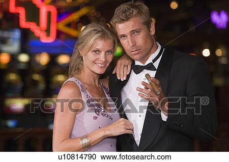 Couple in casino with cigar smiling (selective focus) View Large Photo Image Stock Image - Couple in casino with cigar smiling (selective focus). Fotosearch