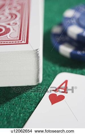 Deck of cards and poker chips on a poker table with ace of hearts showing (close up/selective focus) View Large Photo Image Picture - Deck of cards and poker chips on a poker table with ace of hearts showing (close up/selective focus). Fotosearch