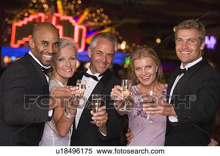 Stock Photography - Five people in casino with champagne smiling (selective focus). Fotosearch