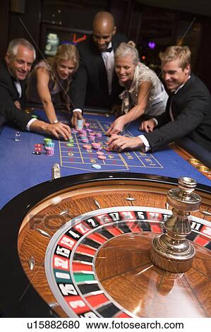 Group of people in casino playing roulette and smiling (selective focus) View Large Photo Image Stock Image - Group of people in casino playing roulette and smiling (selective focus). Fotosearch